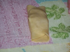 Берем маленькие кусочки теста, разминаем рукой, раскатываем скалкой - 2