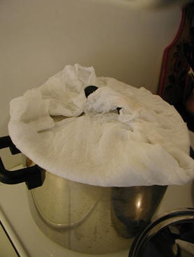Заверните крышку кастрюли в марлю или полотенце и поставьте на газ для заварки риса